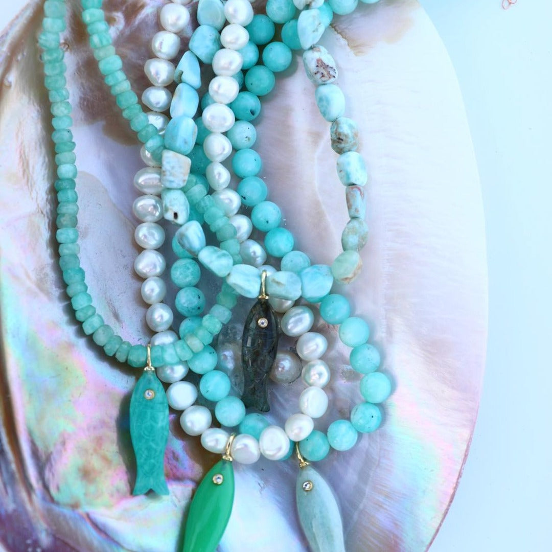 Hand-strung pearl necklace on an abalone shell